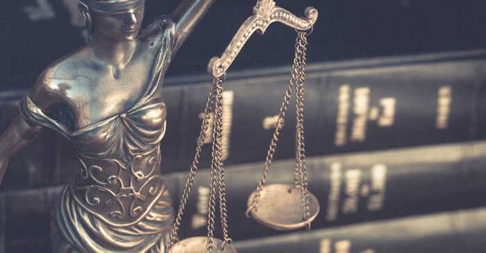 Modell von Justitia neben Bücherstapel