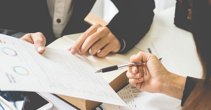 Ein Mann im Anzug und eine Frau besprechen ein Dokument