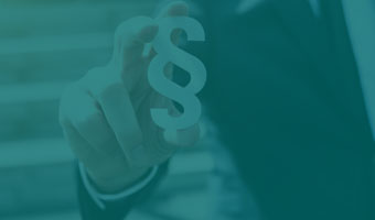 Business Law Absolvent im Anzug haelt Paragraph Zeichen in der Hand